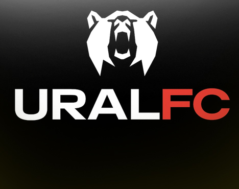 На изображении логотип URAL FC. На черном фоне изображен белый медведь с открытой пастью над текстом URAL белого цвета и FC красного цвета